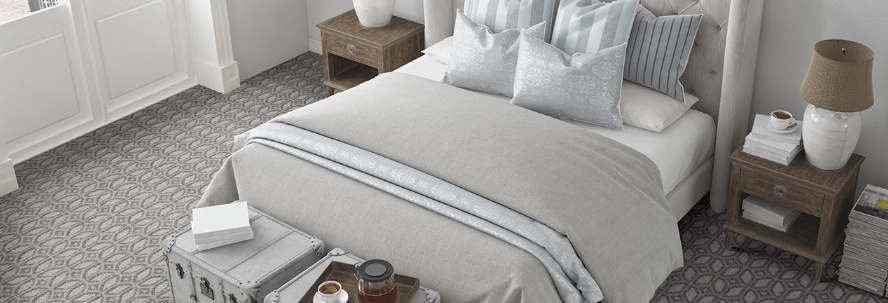 Patterned Karastan carpet elevates the decor in a modern bedroom with solid, neutral-colored linens.